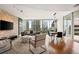 Inviting living room with a decorative stone wall, hardwood floors, and a stunning city view through expansive windows at 20 10Th Nw St # 2003, Atlanta, GA 30309