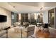 Bright living room featuring a stone accent wall, hardwood floors and expansive windows showcasing city views at 20 10Th Nw St # 2003, Atlanta, GA 30309