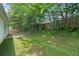 Backyard with green grass, a stone patio, white siding and lush trees at 5478 Somer Mill Rd, Douglasville, GA 30134