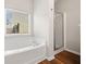 Bright bathroom featuring soaking tub, separate shower, and wood look floors at 5478 Somer Mill Rd, Douglasville, GA 30134