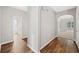 Neutral hallway featuring wood floors, arched doorways, and views into adjacent rooms and bathroom at 5478 Somer Mill Rd, Douglasville, GA 30134