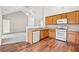 Spacious kitchen featuring oak cabinets, white appliances, and a view into the living room at 5478 Somer Mill Rd, Douglasville, GA 30134