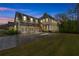 Stunning two-story home with a three-car garage and manicured lawn at dusk at 6351 Granbury Nw Walk, Acworth, GA 30101
