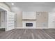 Stylish living room with gray plank flooring, modern fireplace, and white shiplap accent wall at 6351 Granbury Nw Walk, Acworth, GA 30101