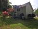 Backyard view with mature trees, green grass, and partial house view at 2122 Riverbirch Ct, Lawrenceville, GA 30044