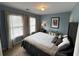 This bedroom has blue walls, carpet, a bed, and two windows at 2122 Riverbirch Ct, Lawrenceville, GA 30044
