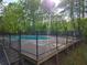 A fenced in outdoor pool surrounded by a wood deck and lush greenery at 2122 Riverbirch Ne Ct, Lawrenceville, GA 30044