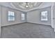 Spacious bedroom with a tray ceiling, ceiling fan and plush gray carpeting at 405 Sable Trace Cv, Acworth, GA 30102