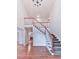 Bright foyer featuring hardwood floors, a staircase with wood railing, and a view of the living room at 405 Sable Trace Cv, Acworth, GA 30102