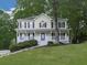 Inviting two-story home with a classic front porch, white railings, and a lush green lawn at 405 Sable Trace Cv, Acworth, GA 30102