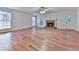 An empty living room features a stone fireplace, hardwood floors, and multiple windows for natural light at 405 Sable Trace Cv, Acworth, GA 30102