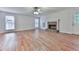 Living room with hardwood floors, natural light from multiple windows, and a stone fireplace at 405 Sable Trace Cv, Acworth, GA 30102