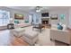 Bright living room featuring hardwood floors, a stone fireplace, and comfortable seating arrangements at 405 Sable Trace Cv, Acworth, GA 30102