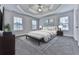 Luxurious main bedroom with tray ceilings, plush carpet, and large windows with natural light at 405 Sable Trace Cv, Acworth, GA 30102