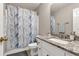 This bathroom has granite counters, a large mirror, and shower-tub with decorative curtain at 420 Bear Cub Path, Social Circle, GA 30025