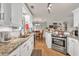 Bright kitchen featuring stainless steel oven, granite countertops, sink and white cabinets at 420 Bear Cub Path, Social Circle, GA 30025