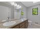 A modern bathroom with dual sinks, granite countertops, and a large mirror at 4811 Nevilly Way, Marietta, GA 30066