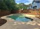 Backyard pool featuring concrete decking, wood fence and surrounded by mature trees at 4811 Nevilly Way, Marietta, GA 30066