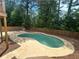 Backyard kidney-shaped pool features a concrete patio and surrounded by a wooden fence at 4811 Nevilly Way, Marietta, GA 30066