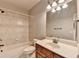 Bathroom with a shower and tub combination, tile walls and a light countertop at 5195 Stefan Ridge Way, Buford, GA 30519