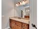 Bathroom featuring granite countertops, wooden cabinets, and modern lighting fixtures at 5195 Stefan Ridge Way, Buford, GA 30519