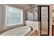 Bathroom features a soaking tub, tiled shower, and large window at 5195 Stefan Ridge Way, Buford, GA 30519