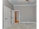 Neutral bedroom with grey walls, white trim, a carpeted floor, and two white doors at 5195 Stefan Ridge Way, Buford, GA 30519