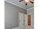 Neutral bedroom with grey walls, white trim, a ceiling fan, carpeted floor, and two white doors at 5195 Stefan Ridge Way, Buford, GA 30519