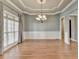 Dining room featuring hardwood floors, coffered ceiling, wainscoting and modern chandelier at 5195 Stefan Ridge Way, Buford, GA 30519