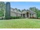 Stately brick home with a well-manicured lawn and mature landscaping at 5195 Stefan Ridge Way, Buford, GA 30519