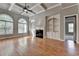 Spacious living room featuring hardwood floors, custom built-ins, fireplace, coffered ceiling, and large windows at 5195 Stefan Ridge Way, Buford, GA 30519