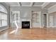 Bright living room features a fireplace and built-in shelving, with large window and beautiful hardwood floors at 5195 Stefan Ridge Way, Buford, GA 30519