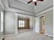 Bright main bedroom with tray ceilings, decorative columns, and neutral carpeting at 5195 Stefan Ridge Way, Buford, GA 30519