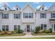 Attractive townhome features gray siding, neat landscaping, a red front door, and shaded seating area at 1702 Prospect Way, Conyers, GA 30094