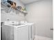 Neat laundry room showcasing a white washer and dryer set with wire shelving at 1702 Prospect Way, Conyers, GA 30094