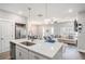 Open concept kitchen with island bar seating overlooking the living room and dining room at 1702 Prospect Way, Conyers, GA 30094