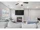 Bright living room with fireplace, TV, fan, and cozy sectional sofa with stylish pillows at 1702 Prospect Way, Conyers, GA 30094