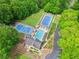 Aerial view showcasing a pool, tennis courts, and clubhouse surrounded by greenery, offering recreational opportunities at 22 Oakwood Hills Dr, Suwanee, GA 30024