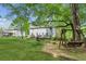 Spacious backyard with mature trees, a large deck, and a charming porch in the distance, perfect for outdoor living at 22 Oakwood Hills Dr, Suwanee, GA 30024