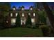 Evening view of a brick home, showcasing its well-lit facade and landscaped front yard at 22 Oakwood Hills Dr, Suwanee, GA 30024