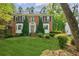 Charming brick home with manicured lawn, mature trees, and classic architectural details at 22 Oakwood Hills Dr, Suwanee, GA 30024