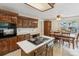 Traditional kitchen with wood cabinetry, an island cooktop, and adjacent dining area at 22 Oakwood Hills Dr, Suwanee, GA 30024