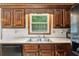 Traditional kitchen with wood cabinets, white countertops, and a window overlooking the backyard at 22 Oakwood Hills Dr, Suwanee, GA 30024