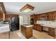 Traditional kitchen with a central island cooktop, dark appliances, and wood cabinetry at 22 Oakwood Hills Dr, Suwanee, GA 30024