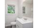 Bright bathroom featuring a white vanity, modern faucet, toilet, and a window that provides natural light at 3367 Misty Valley Rd, Decatur, GA 30032