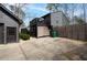 View of the home with a detached garage, deck, and private backyard at 3404 Vinings North Se Trl, Smyrna, GA 30080