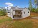 Exterior shot showing the backyard with the back of the house including a deck and a retaining wall at 8230 Dawson View Way, Cumming, GA 30028