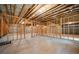 Unfinished basement with concrete floor, open ceiling with exposed beams, and framed walls at 8230 Dawson View Way, Cumming, GA 30028
