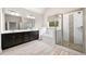 Elegant bathroom features a double sink vanity, soaking tub, and glass-enclosed shower with tiled walls at 8230 Dawson View Way, Cumming, GA 30028