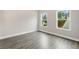Bright bedroom featuring hardwood floors, neutral paint, and natural light from two windows at 8230 Dawson View Way, Cumming, GA 30028